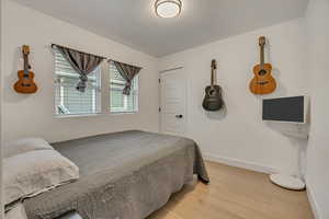Bedroom with light wood-style flooring and a textured ceiling