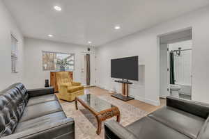 Living room with light wood-style flooring and recessed lighting