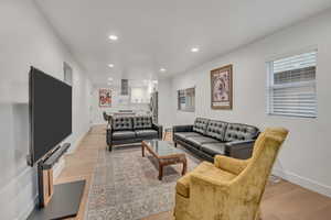 Living area with light wood-style flooring and recessed lighting
