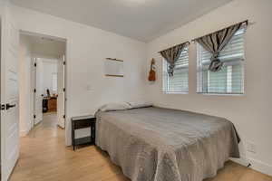 Bedroom with light wood-type flooring and baseboards