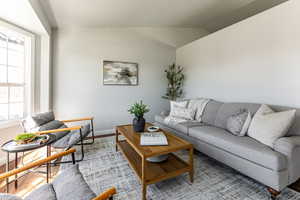 Living area featuring vaulted ceiling and light wood finished floors