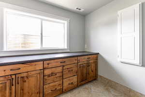 Bathroom with vanity, light tile patterned flooring, and a textured ceiling