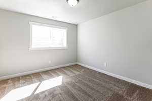 Empty room featuring carpet and a textured ceiling