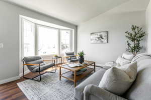 Living area with vaulted ceiling and wood finished floors