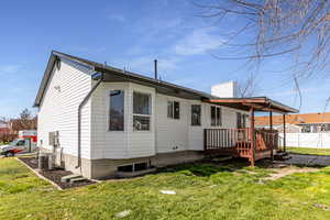 Rear view of house with a wooden deck and a chimney