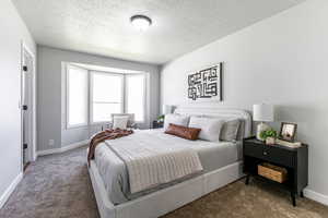 Bedroom featuring a textured ceiling and carpet floors