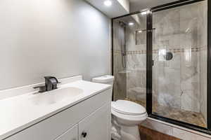 Full bath with vanity, a shower stall, and recessed lighting