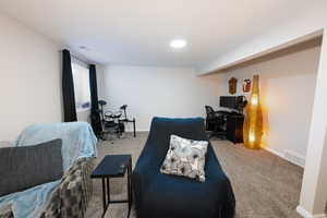 Bedroom featuring an office area and light carpet