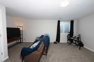 Carpeted living area featuring baseboards
