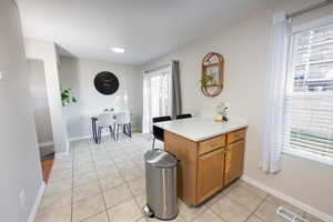 Kitchen featuring wood finish cabinets, light tile patterned floors, and a peninsula