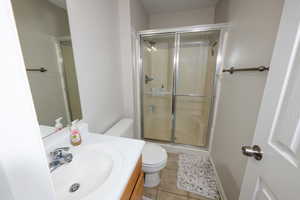 Bathroom with vanity, a stall shower, and light tile patterned floors