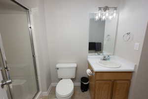 Bathroom with vanity, a stall shower, and light tile patterned floors