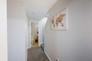Corridor featuring carpet flooring and baseboards