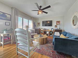 Living room with light wood-type flooring and ceiling fan