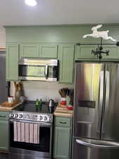 Kitchen featuring green cabinetry and stainless steel appliances