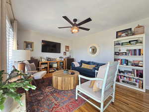 Living area featuring wood finished floors and a ceiling fan
