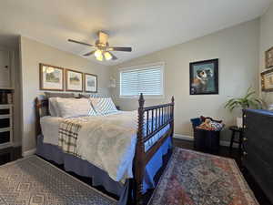 Bedroom with ceiling fan, dark wood-type flooring, and vaulted ceiling