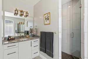 Bathroom featuring vanity and a shower stall
