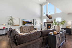 Living area featuring hardwood / wood-style flooring, a high ceiling, and a fireplace
