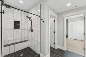 Full bathroom featuring a stall shower, dark marble finish flooring, and recessed lighting