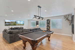 Playroom featuring light wood-type flooring, a textured ceiling, pool table, and recessed lighting