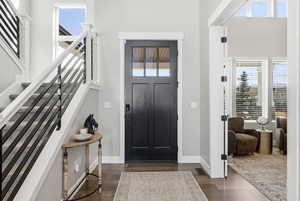 Foyer featuring healthy amount of natural light, dark wood-type flooring, and a high ceiling