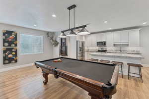 Recreation room with billiards, a textured ceiling, light wood-type flooring, and recessed lighting