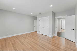 Unfurnished bedroom featuring light wood-style floors, recessed lighting, and a closet