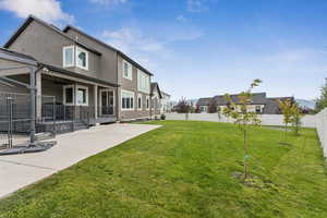 Fenced backyard with a patio area, ceiling fan, and a residential view