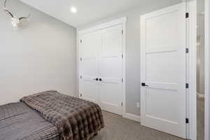 Bedroom with light colored carpet, a closet, and recessed lighting