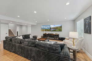 Living room featuring light wood-style flooring, recessed lighting, and a textured ceiling