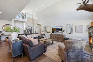 Living area featuring a fireplace, a high ceiling, hardwood / wood-style flooring, and hanging lights