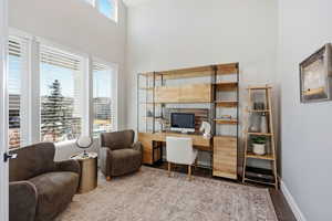 Office space featuring wood finished floors and a high ceiling
