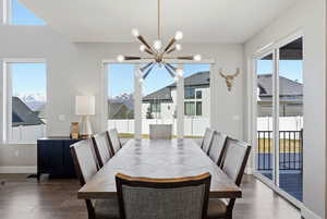 Dining area with a chandelier, plenty of natural light, and dark wood-style flooring