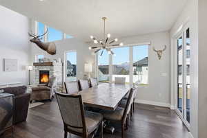 Dining area with a fireplace, a chandelier, and dark wood finished floors