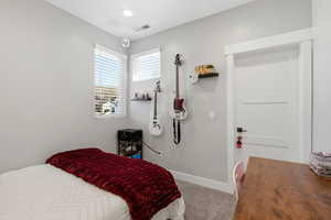 Bedroom featuring carpet and baseboards
