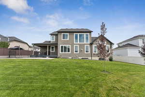 Rear view of property featuring a fenced backyard, a patio, and stucco siding