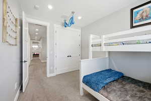 Bedroom with light colored carpet and recessed lighting