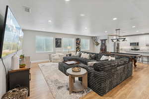 Living area featuring a textured ceiling, light wood-type flooring, and recessed lighting