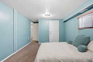 Bedroom featuring a textured ceiling and carpet