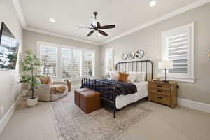 Main Floor Primary Bedroom featuring light carpet, ornamental molding, a ceiling fan, and recessed lighting