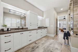 Primary Ensuite bathroom featuring double vanity, a ceiling fan, and light wood-style flooring