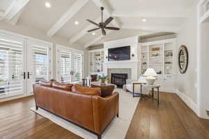 Living room with hardwood / wood-style floors, recessed lighting, french doors, a glass covered fireplace, and a ceiling fan
