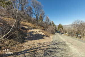 View of asphalt street featuring a mountain view