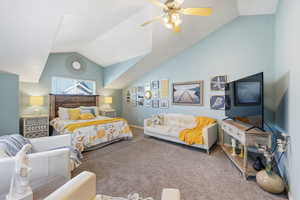 Bedroom featuring natural light, carpet flooring, lofted ceiling, and a ceiling fan
