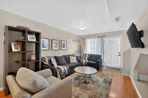 Living area featuring light wood-type flooring and a textured ceiling