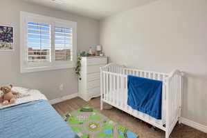 Bedroom with carpet flooring and a crib