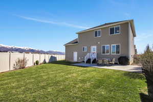 Rear view of property with a mountain view and a patio