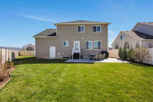 Back of house featuring a fenced backyard, a patio, and entry steps