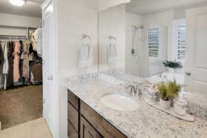Full bath featuring a walk in closet, vanity,  a shower stall, and a bath